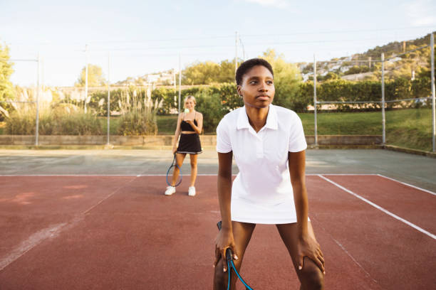 istock Two young women playing tennis 1720176373