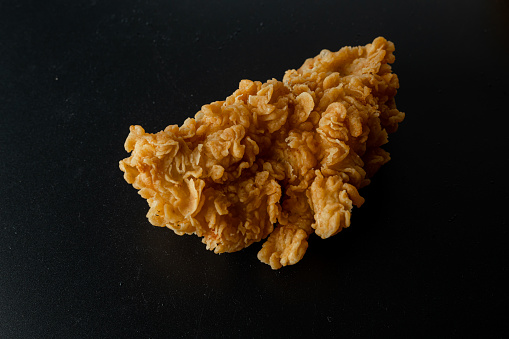 Crispy fried chicken isolated on black background. Fresh crunchy fried chicken on a white plate. Delicious hot and crispy fried chicken. Image about food of fast food restaurant.
