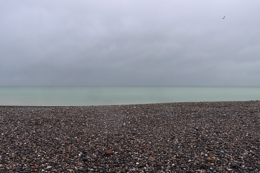 Empty beach a stormy dark sky and rolling waves.