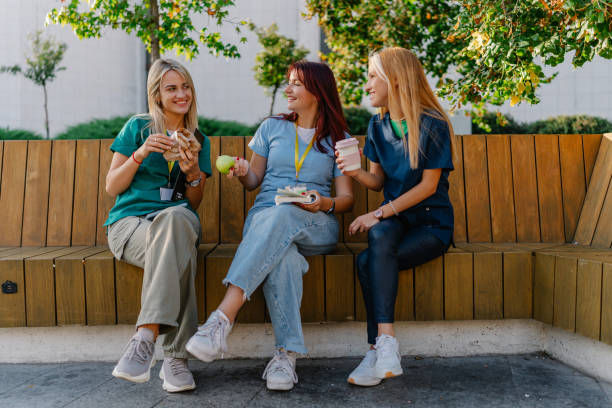 istock Three young female nurses sitting on a park bench and talking 1720207463