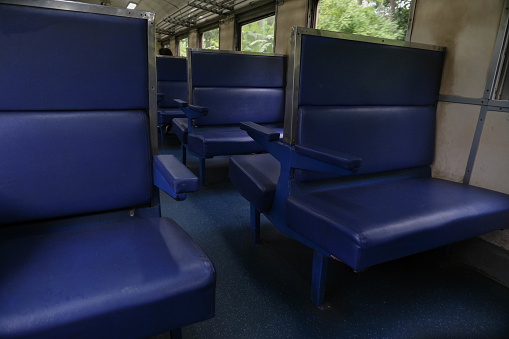 Empty blue seats inside train cabin.