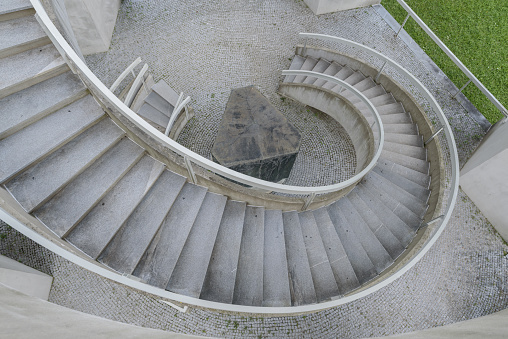 Top view of spiral staircase in shades of grey with green grass on the side
