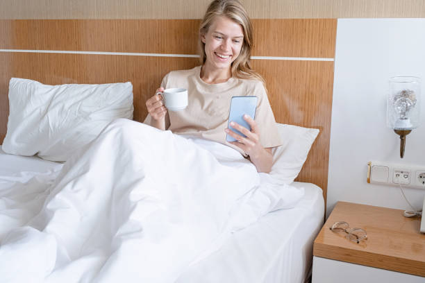 istock Woman using smartphone lying in bed and drinking coffee 1720247125