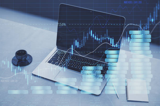 istock Close up of laptop at workplace with coffee cup and creative forex chart hologram with growing stacked coins. Financial growth, trade and market concept. Double exposure. 1720260697