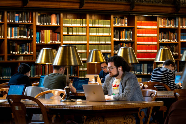 un estudiante adulto maduro aprendiendo en una biblioteca pública - new york city new york public library indoors bookshelf fotografías e imágenes de stock