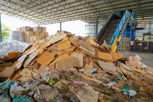 Nakhon Ratchasima - September 14, 2023 Bales of cardboard and box board with strapping wire ties before shredding at recycling plant