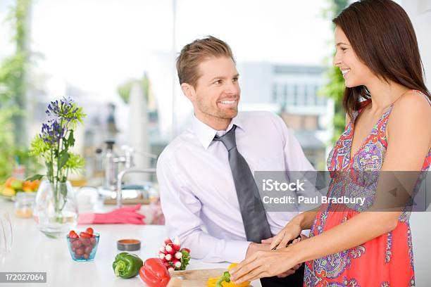 Marido Hablando De Mujer Mientras La Paciente Parte De Las Verduras En La Cocina Foto de stock y más banco de imágenes de 25-29 años