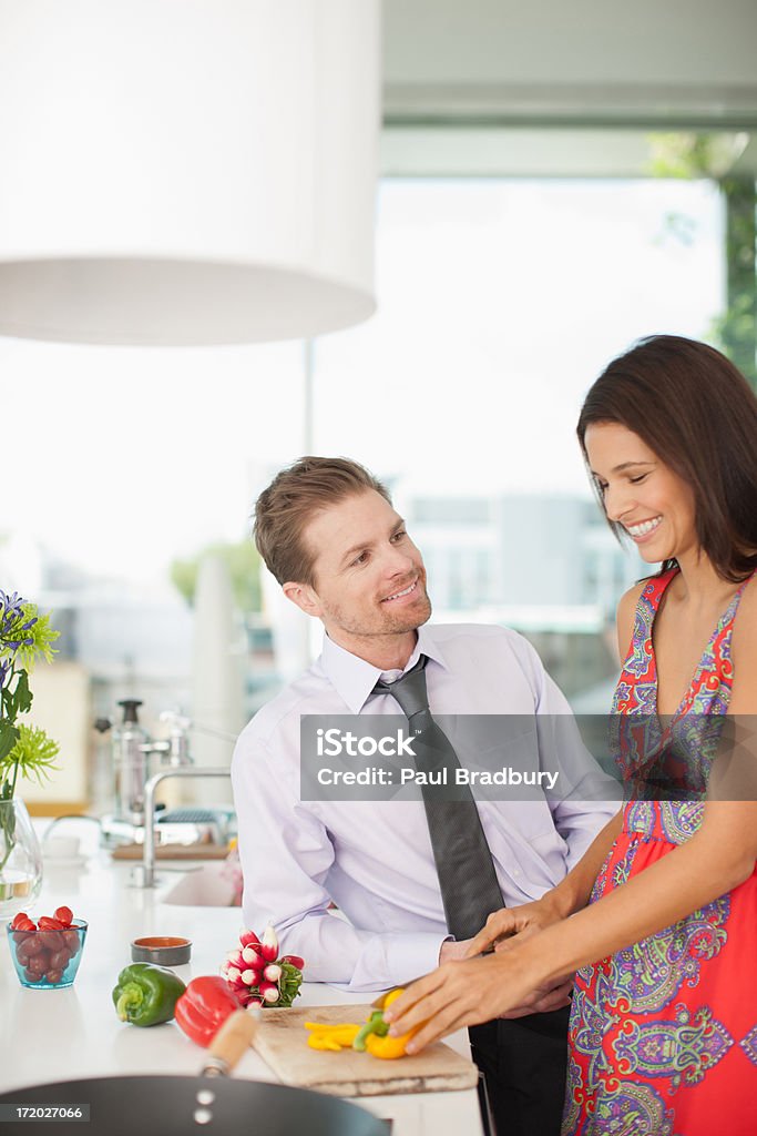Муж и жена во время беседы она создает овощи в кухне - Стоковые фото Бизнес роялти-фри