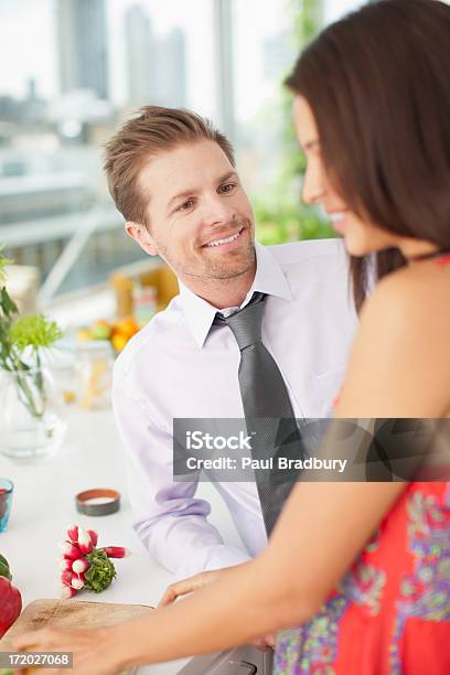 Marido Hablando De Mujer Mientras La Paciente Parte De Las Verduras En La Cocina Foto de stock y más banco de imágenes de 25-29 años