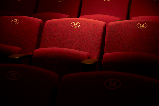 Empty, red theatre seats, numbered