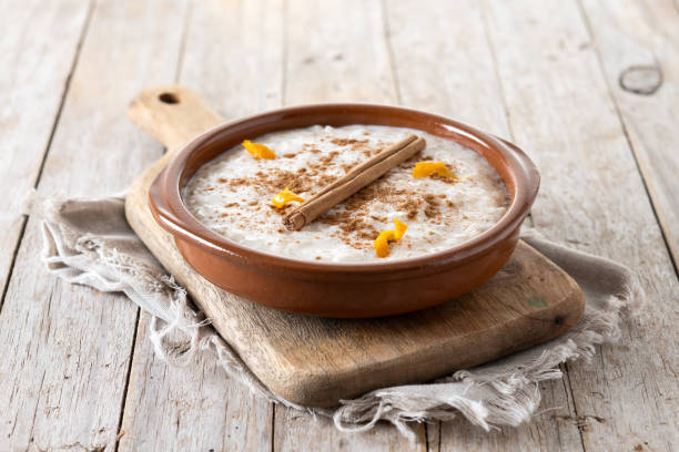 arroz con leche. budino di riso con cannella in ciotola su tavolo di legno - rice pudding foto e immagini stock