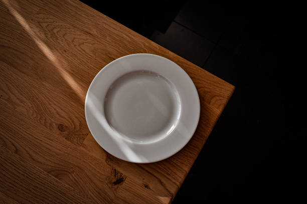 istock Ceramic white flat plate for food on wooden table top view 1720309855
