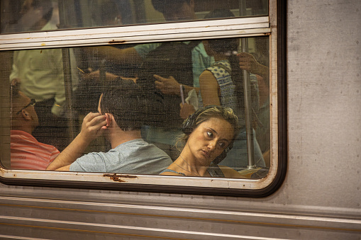 New York Subway, Manhattan, New York, USA - August 17th 2023:  People in a subway car seen through the window from the outside