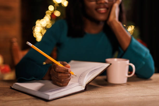 istock Young woman contemplating her New Year's resolutions and writing them in a diary 1720322590