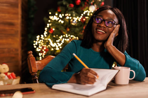 istock Young woman contemplating her New Year's resolutions and writing them in a diary 1720326461