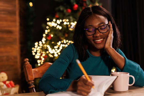 istock Young woman contemplating her New Year's resolutions and writing them in a diary 1720329276