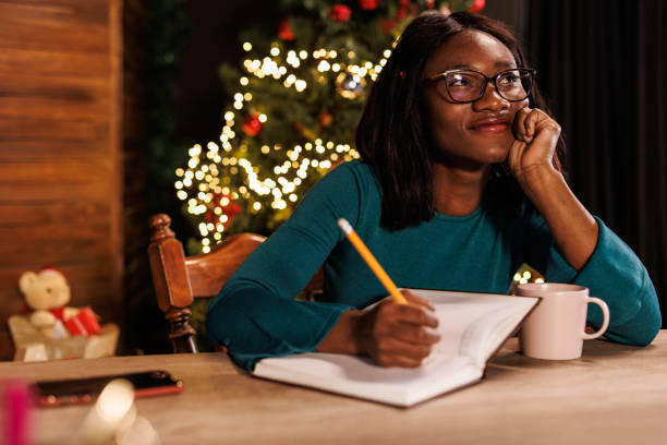 istock Young woman contemplating her New Year's resolutions and writing them in a diary 1720332103