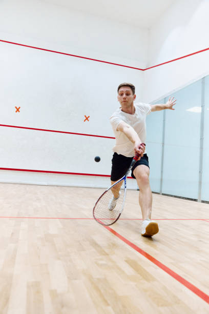 istock Young concentrated, athletic man playing squash, training on squash court, hitting ball with racket. 1720335389