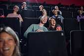 Carefree couple watching a comedy movie in cinema.