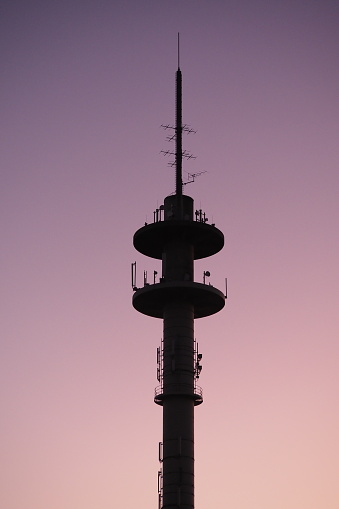 Shilouette of communication tower with many antennas at sunset and colorful sky