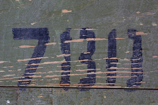 Green wood texture background from army ammunition wooden crate with abstract black color number.