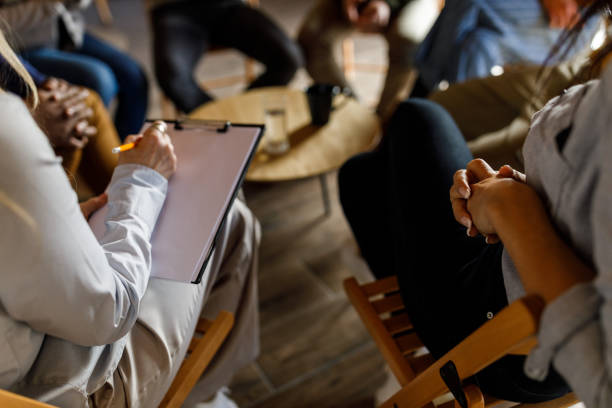 istock Female therapist holding a clipboard for note taking during a group therapy session 1720351288