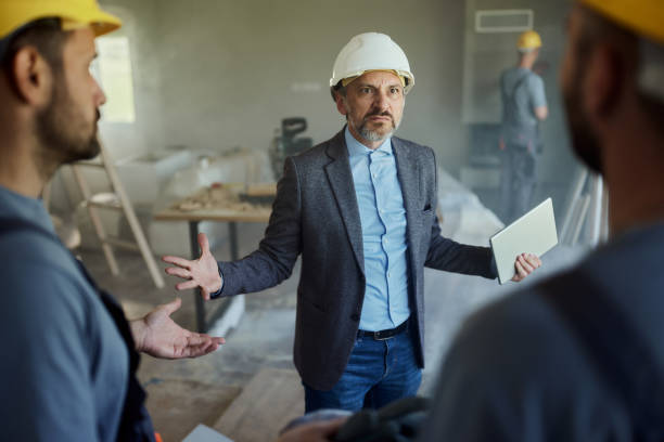 istock Male architect arguing with his workers during home renovation process. 1720356335