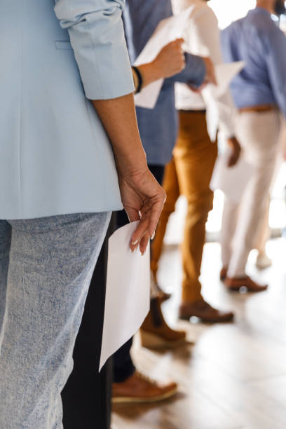 bizneswoman trzymająca swoje cv, czekając w kolejce na rozmowę kwalifikacyjną - unemployment waiting in line waiting room interview zdjęcia i obrazy z banku zdjęć