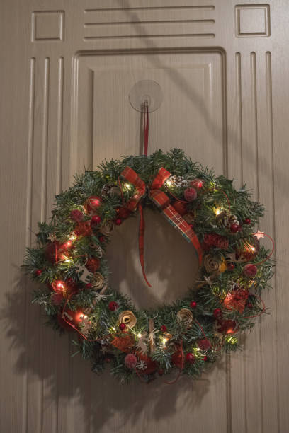 istock illuminated christmas wreath hanging on the door 1720374665