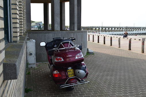 Blankenberge, West-Flanders, Belgium-September 30, 2023: beautiful expensive vintage purple 2-seater luxury easy rider motorcycle Goldwing Honda stationary on promenade next to beach and lighthouse