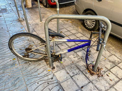 High angle view of bicycle lying on the sidewalk with a missing wheel in the city of Valencia, Spain