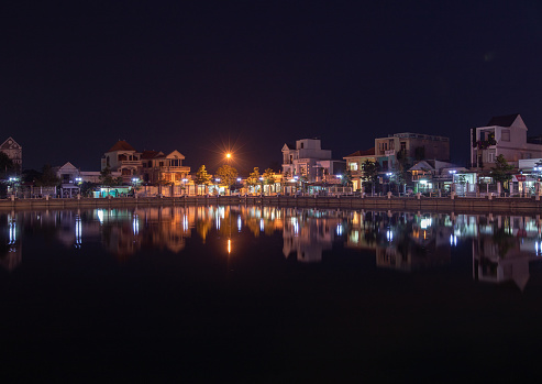 Go Cong town reflected by the Racetrack pond at night, Tien Giang province
