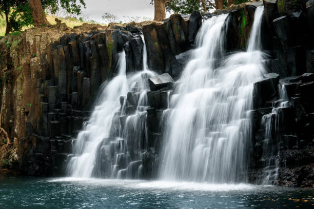 istock Cascade waterfall with black rocks in Mauritius island 1720439876