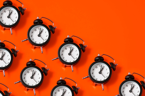 Alarm clock in a row with copy space on red background