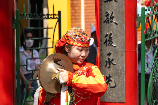 Hoi An - Vietnam - 18 January 2023. Young Vietnamese woman playing bell drums at lantern festival hoi an