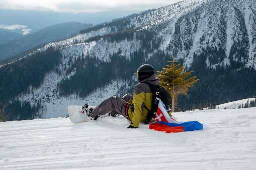 man snowboarder with slovakia flag at ski resort slope beautiful mountains landscape on background