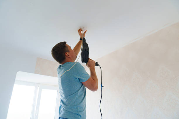 istock A man is working on the installation of a ceiling luminaire on the ceiling. 1720481514