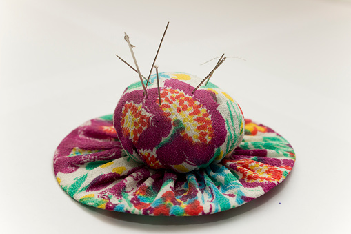 This handmade fabric pin cushion with its vibrant floral pattern and sparkling needles captures the beauty of both art and nature, bringing a little bit of the outdoors inside