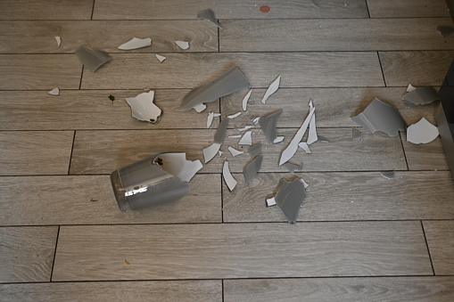 broken glassware on the floor, the consequences of a quarrel smashed glassware on the gray floor