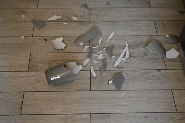 broken glassware on the floor, the consequences of a quarrel smashed glassware on the gray floor - pottery shard imagens e fotografias de stock