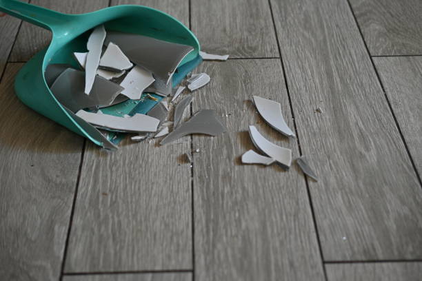 istock broken glassware on the floor is collected in a garbage scoop, the consequences of a quarrel are removed broken glassware on the gray floor 1720503132
