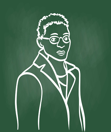 Young adult of African decent in England.  He is wearing eyeglasses and a dresscoat.