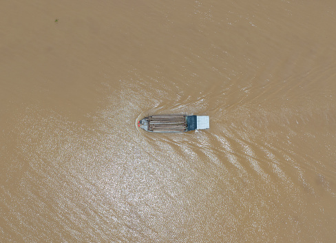Abstract aerial photo of a wooden boat running on the Tien River, Mekong River, Tien Giang province