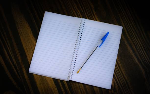 istock Top view of a blank notepad and pen on the wooden table 1720544483