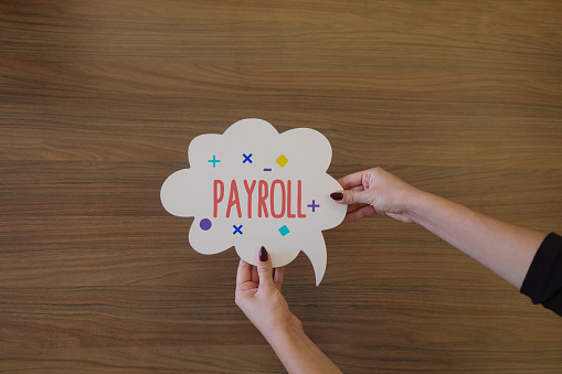 Woman holding speech bubble with payroll word