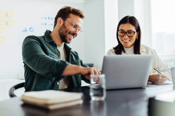 istock Two business people using a laptop together in an office 1720565768