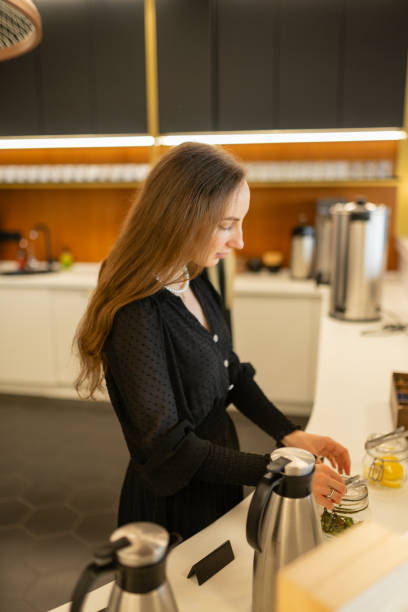 istock Longhaired woman makes herbal hot tea with honey in kitchen 1720569229