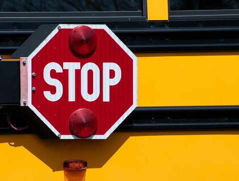 Stop Sign on Yellow School Bus Close Up Image