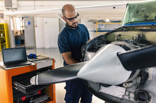 an aircraft mechanic is servicing the plane in the workshop