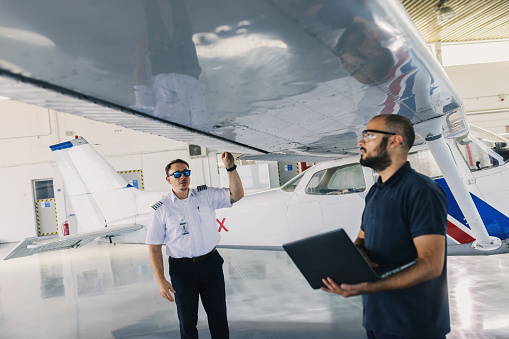 the aircraft mechanic and the pilot inspect the plane before take-off